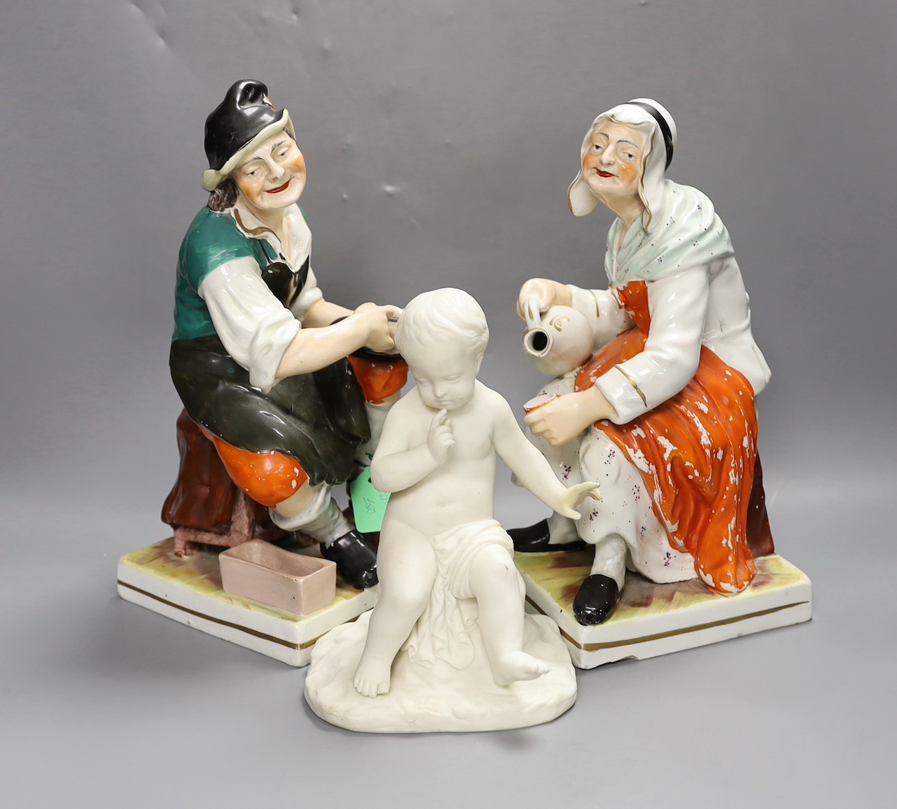 A Copeland Parian figure of a putti (hand a.f.) and two Staffordshire figures, tallest 32cm